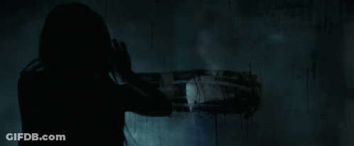 A Close Up Of A Woman 'S Face In The Dark With Her Mouth Open GIF