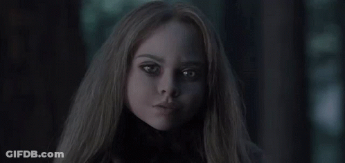 A Close Up Of A Woman 'S Face In The Dark With Long Hair . GIF