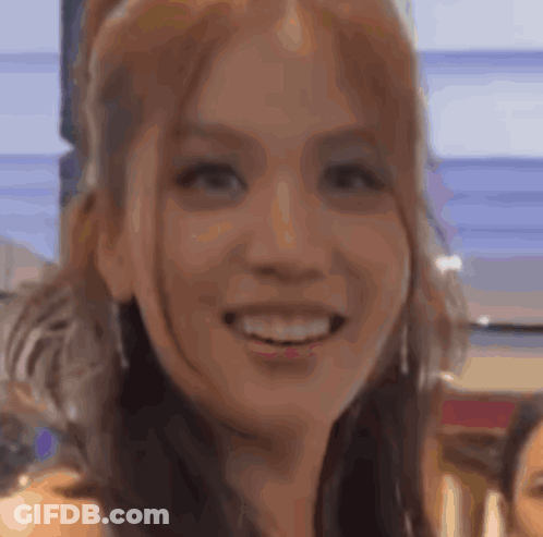 A Close Up Of A Woman 'S Face Smiling With A Blurry Background . GIF