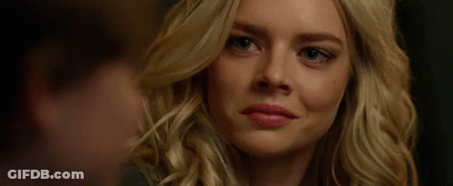 A Close Up Of A Woman 'S Face Smiling With A Man Behind Her . GIF