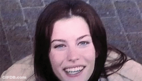 A Close Up Of A Woman 'S Face Smiling With Braces On Her Teeth . GIF