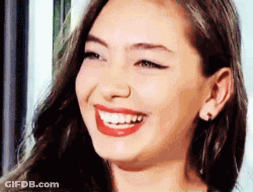 A Close Up Of A Woman 'S Face Smiling With Red Lips GIF