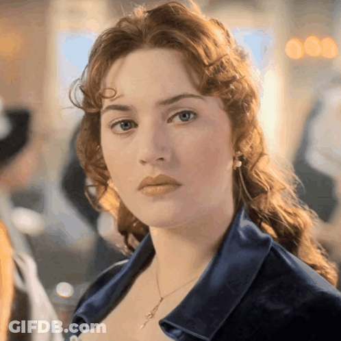 A Close Up Of A Woman 'S Face Wearing A Blue Shirt GIF