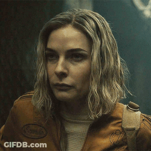 A Close Up Of A Woman 'S Face Wearing A Brown Jacket GIF