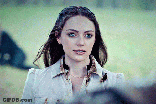 A Close Up Of A Woman 'S Face Wearing A Denim Jacket GIF