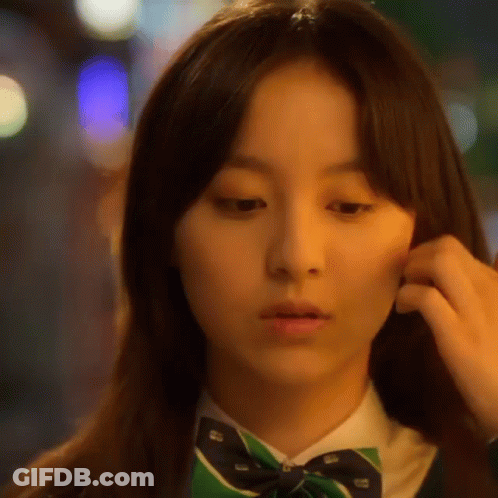A Close Up Of A Woman 'S Face Wearing A Green Bow Tie GIF