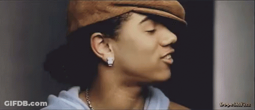 A Close Up Of A Woman 'S Face Wearing A Hat And Earrings GIF