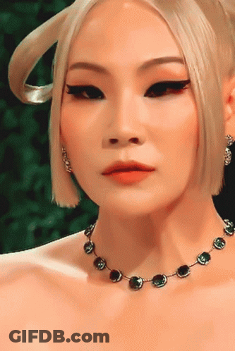 A Close Up Of A Woman 'S Face Wearing A Necklace GIF