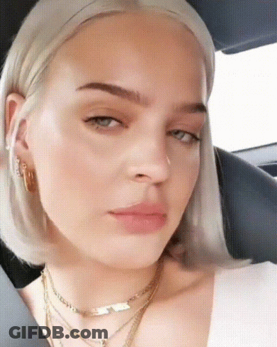 A Close Up Of A Woman 'S Face Wearing A Necklace GIF