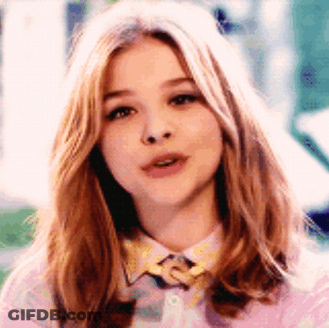 A Close Up Of A Woman 'S Face Wearing A Pink Shirt And A Yellow Bow Tie . GIF
