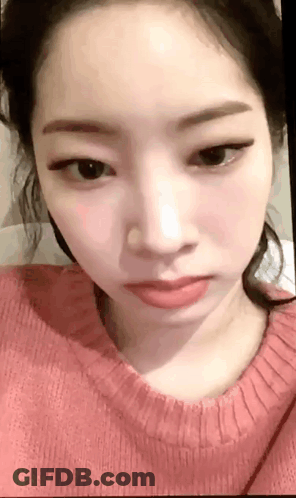 A Close Up Of A Woman 'S Face Wearing A Pink Sweater And Red Lipstick . GIF