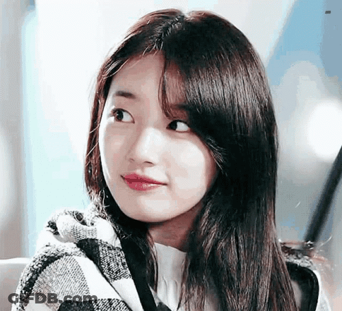 A Close Up Of A Woman 'S Face Wearing A Plaid Scarf . GIF