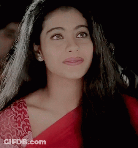 A Close Up Of A Woman 'S Face Wearing A Red Blouse GIF