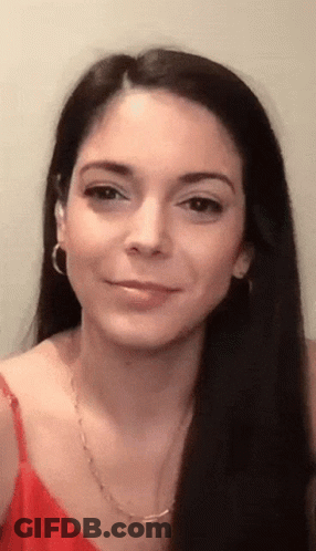 A Close Up Of A Woman 'S Face Wearing A Red Tank Top And Earrings GIF