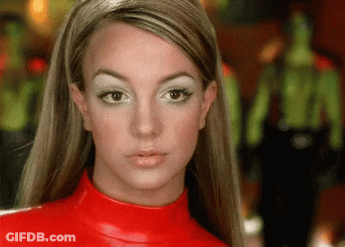 A Close Up Of A Woman 'S Face Wearing A Red Turtleneck Sweater . GIF
