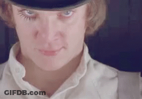 A Close Up Of A Woman 'S Face Wearing A Top Hat And Suspenders . GIF