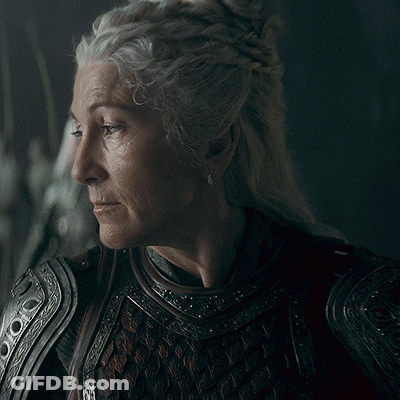 A Close Up Of A Woman 'S Face Wearing Armor And Earrings GIF
