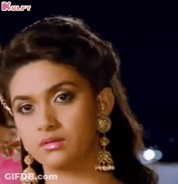 A Close Up Of A Woman 'S Face Wearing Earrings And A Crown . GIF