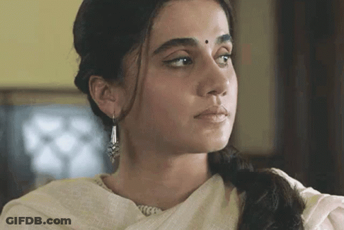 A Close Up Of A Woman 'S Face Wearing Earrings And A White Dress GIF