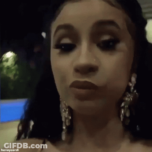 A Close Up Of A Woman 'S Face Wearing Earrings And Making A Funny Face . GIF