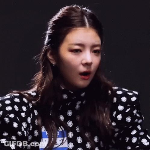 A Close Up Of A Woman 'S Face With A Black And White Polka Dot Dress GIF