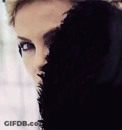 A Close Up Of A Woman 'S Face With A Black Fur Coat Covering Half Of Her Face . GIF
