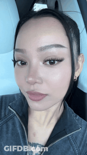 A Close Up Of A Woman 'S Face With A Black Jacket On GIF