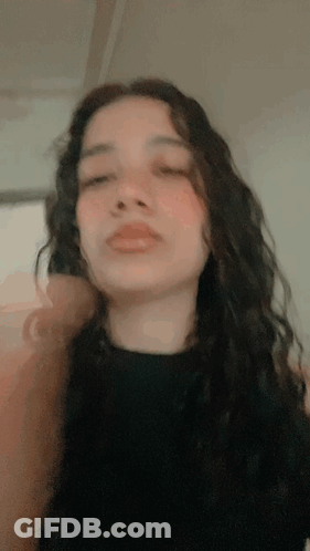 A Close Up Of A Woman 'S Face With A Black Shirt On GIF