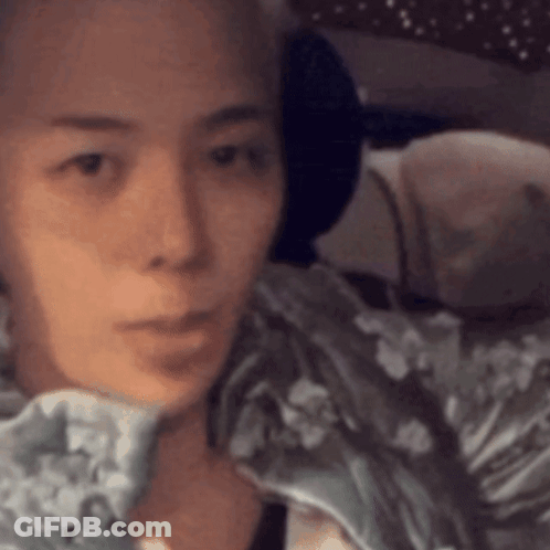 A Close Up Of A Woman 'S Face With A Blanket On Her Shoulder GIF