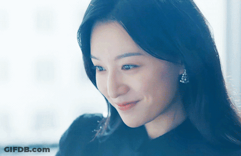 A Close Up Of A Woman 'S Face With A Blue Background GIF