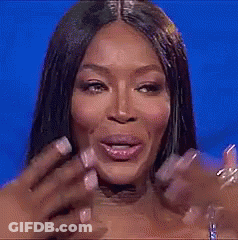 A Close Up Of A Woman 'S Face With A Blue Background And Her Hand On Her Face . GIF