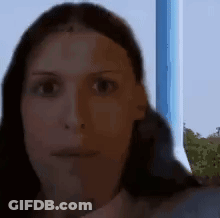 A Close Up Of A Woman 'S Face With A Blue Background GIF