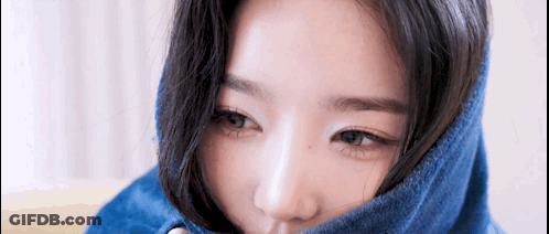 A Close Up Of A Woman 'S Face With A Blue Blanket Covering Her Face . GIF