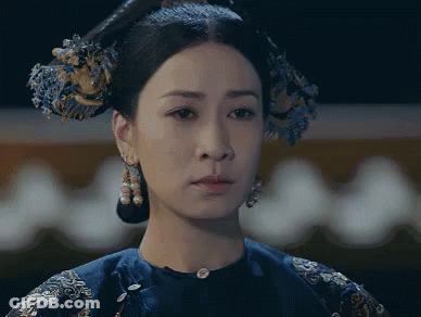 A Close Up Of A Woman 'S Face With A Blue Dress On GIF