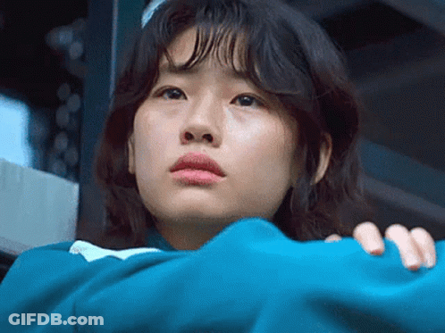 A Close Up Of A Woman 'S Face With A Blue Jacket On . GIF