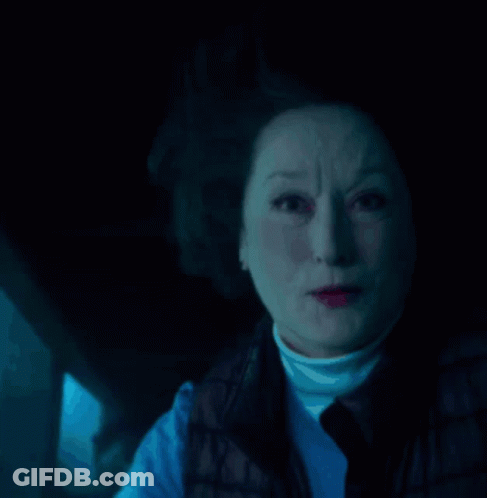 A Close Up Of A Woman 'S Face With A Blue Light Behind Her GIF