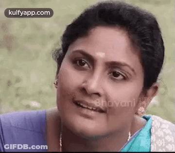 A Close Up Of A Woman 'S Face With A Blue Shirt On . GIF