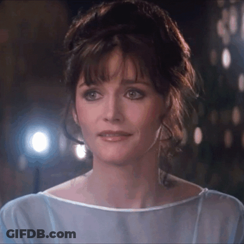 A Close Up Of A Woman 'S Face With A Blue Shirt On GIF