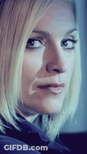 A Close Up Of A Woman 'S Face With A Blue Shirt On GIF