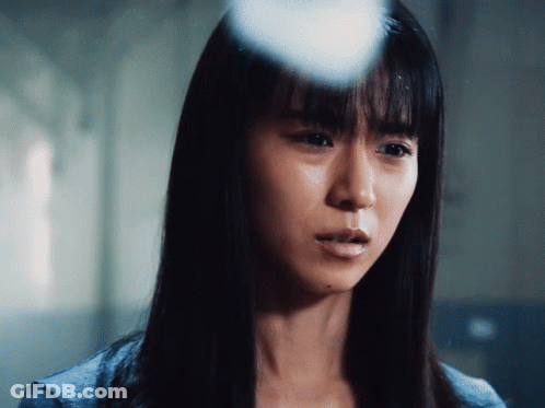 A Close Up Of A Woman 'S Face With A Blue Shirt On GIF