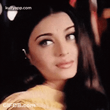 A Close Up Of A Woman 'S Face With A Blurred Background Looking At The Camera . GIF