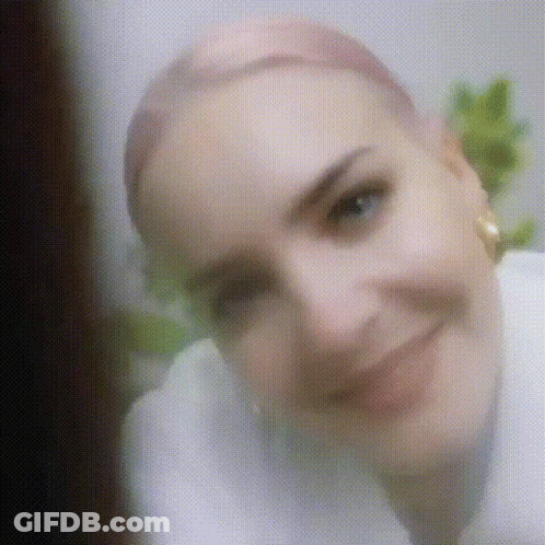 A Close Up Of A Woman 'S Face With A Blurred Background . GIF