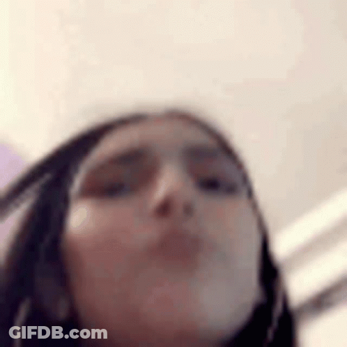 A Close Up Of A Woman 'S Face With A Blurred Background . GIF