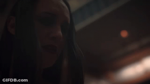 A Close Up Of A Woman 'S Face With A Blurry Background GIF