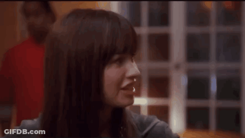 A Close Up Of A Woman 'S Face With A Blurry Background GIF