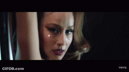 A Close Up Of A Woman 'S Face With A Blurry Background GIF