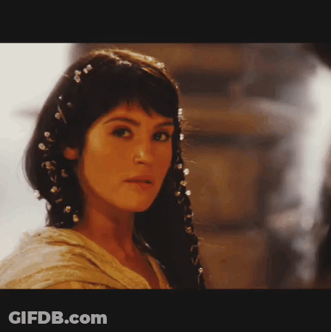 A Close Up Of A Woman 'S Face With A Braid And Pearls In Her Hair GIF