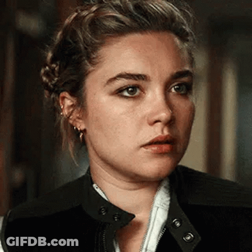 A Close Up Of A Woman 'S Face With A Braid In Her Hair . GIF