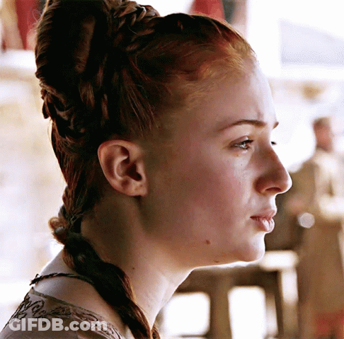 A Close Up Of A Woman 'S Face With A Braided Hairstyle GIF