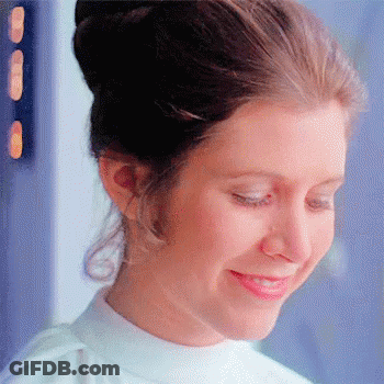 A Close Up Of A Woman 'S Face With A Bun And A Smile On Her Face . GIF